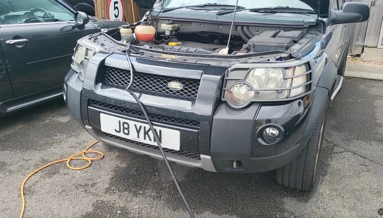 Land Rover Freelander with the bonnet up on a customer's drive, hydrogen hose feeding the intake during a carbon clean