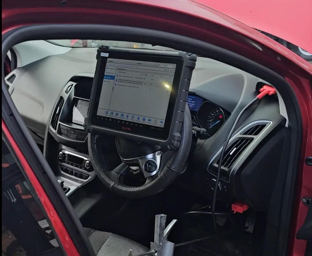 Autel diagnostic tablet mounted on the steering wheel of a Ford, running advanced DPF diagnostics