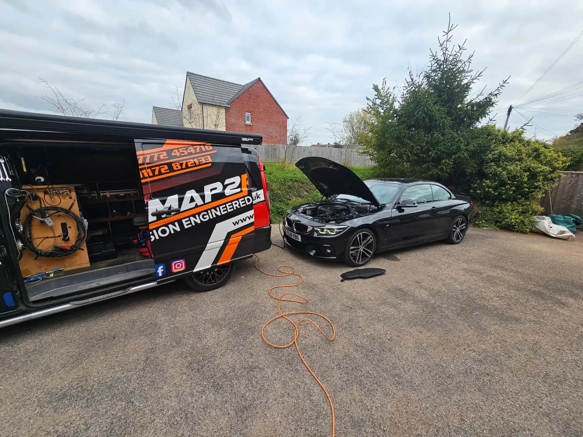 BMW 4 Series with the bonnet up connected to the Remap2Race van for a DPF clean
