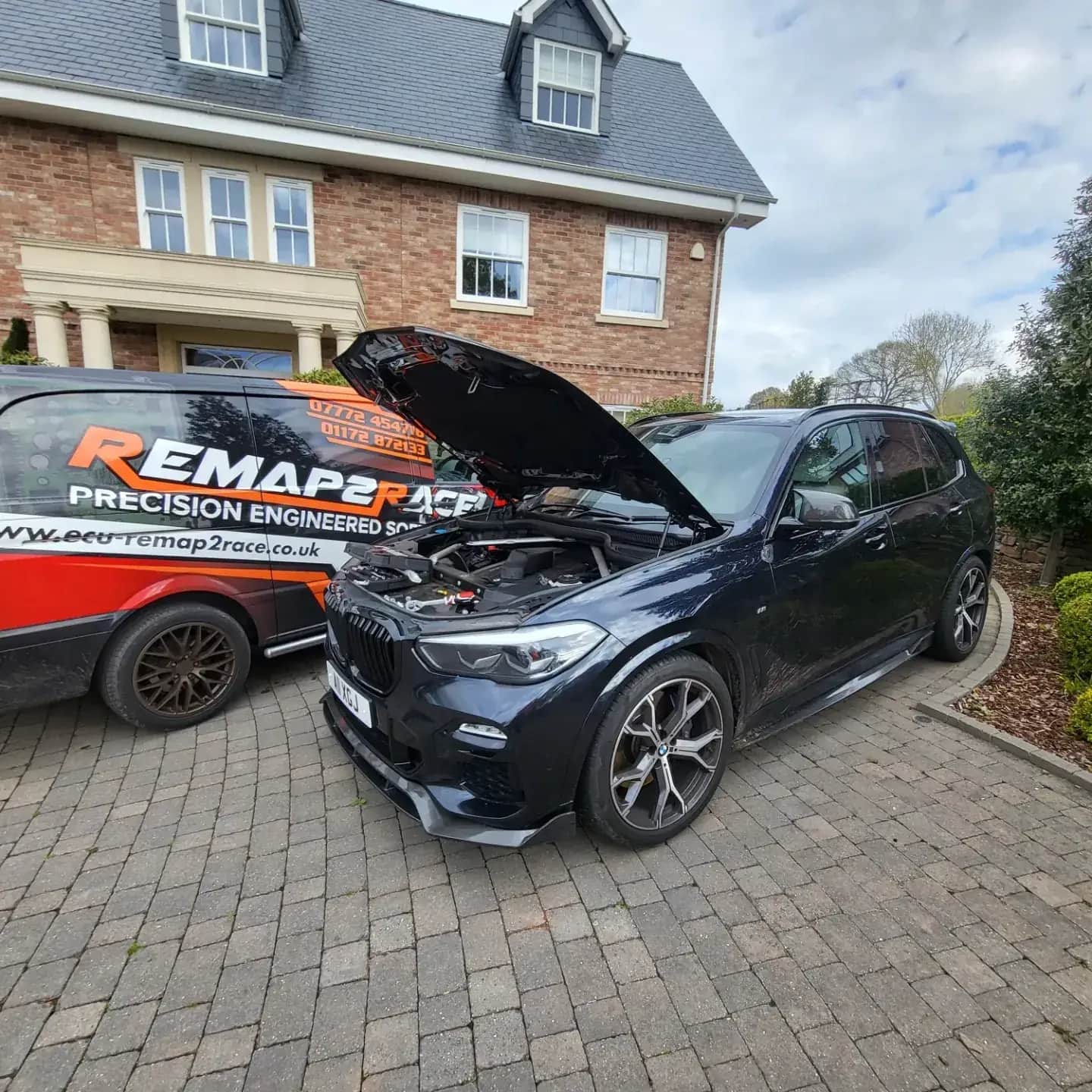BMW X5 with the bonnet up on a customer's driveway, Remap2Race van alongside