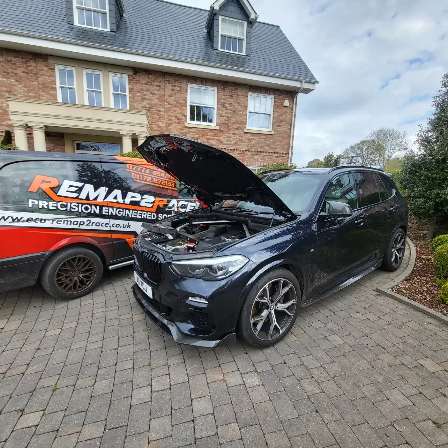 BMW X5 being remapped on a customer's driveway next to the Remap2Race van