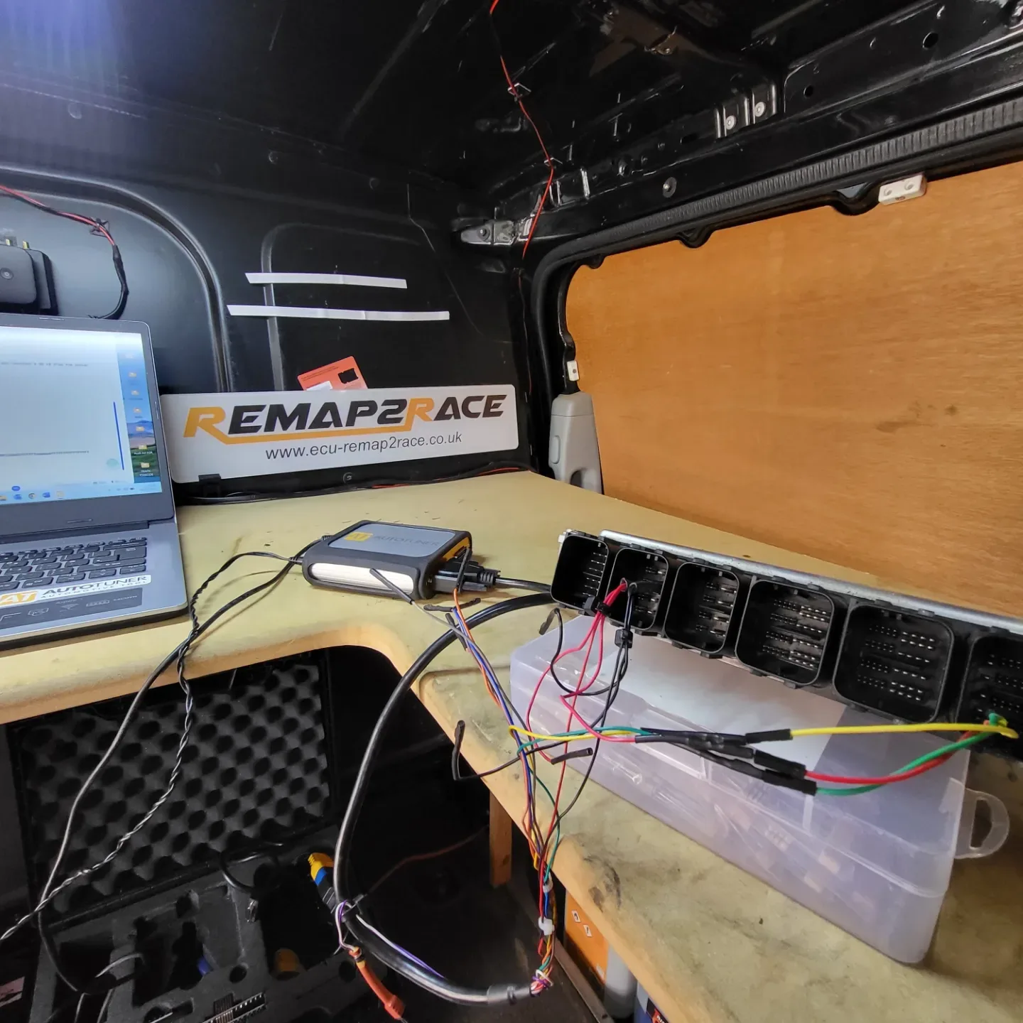 Autotuner connected to an ECU on the workbench inside the Remap2Race van, laptop running the tuning software