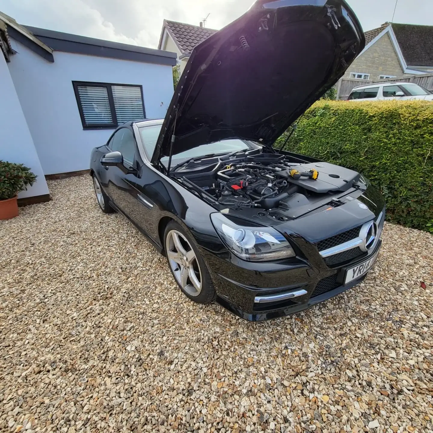 Black Mercedes SLK with the bonnet up on a gravel driveway, ready for a mobile remap