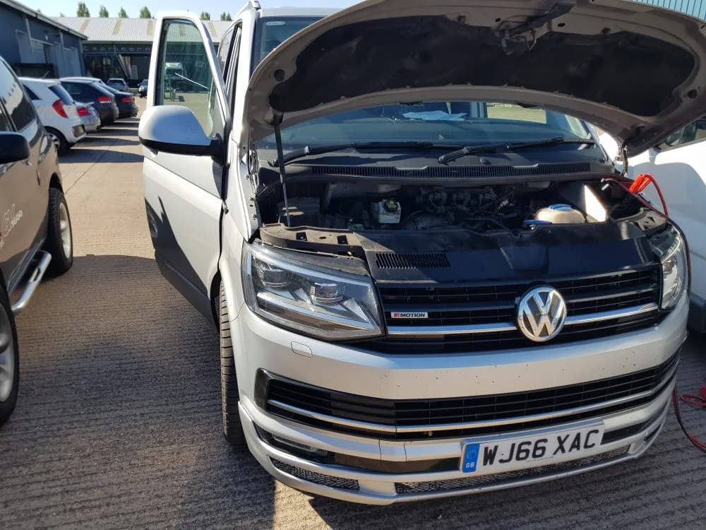 Silver VW T6 Transporter 4Motion with the bonnet up in a yard, connected for a mobile remap