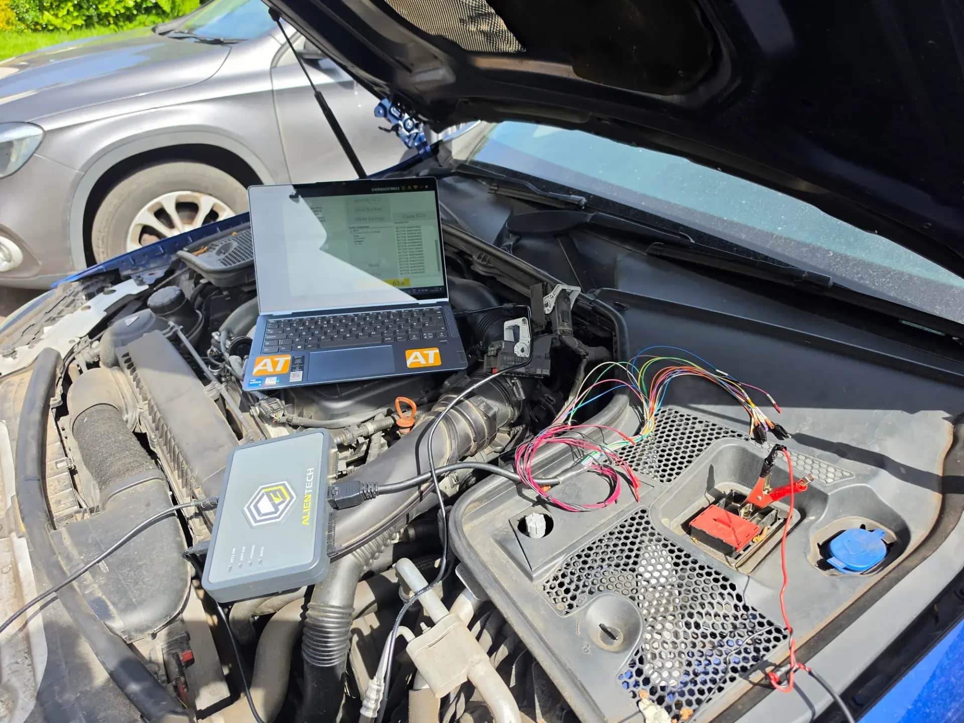 Laptop and Alientech tool reading the ECU in the engine bay during a mobile remap