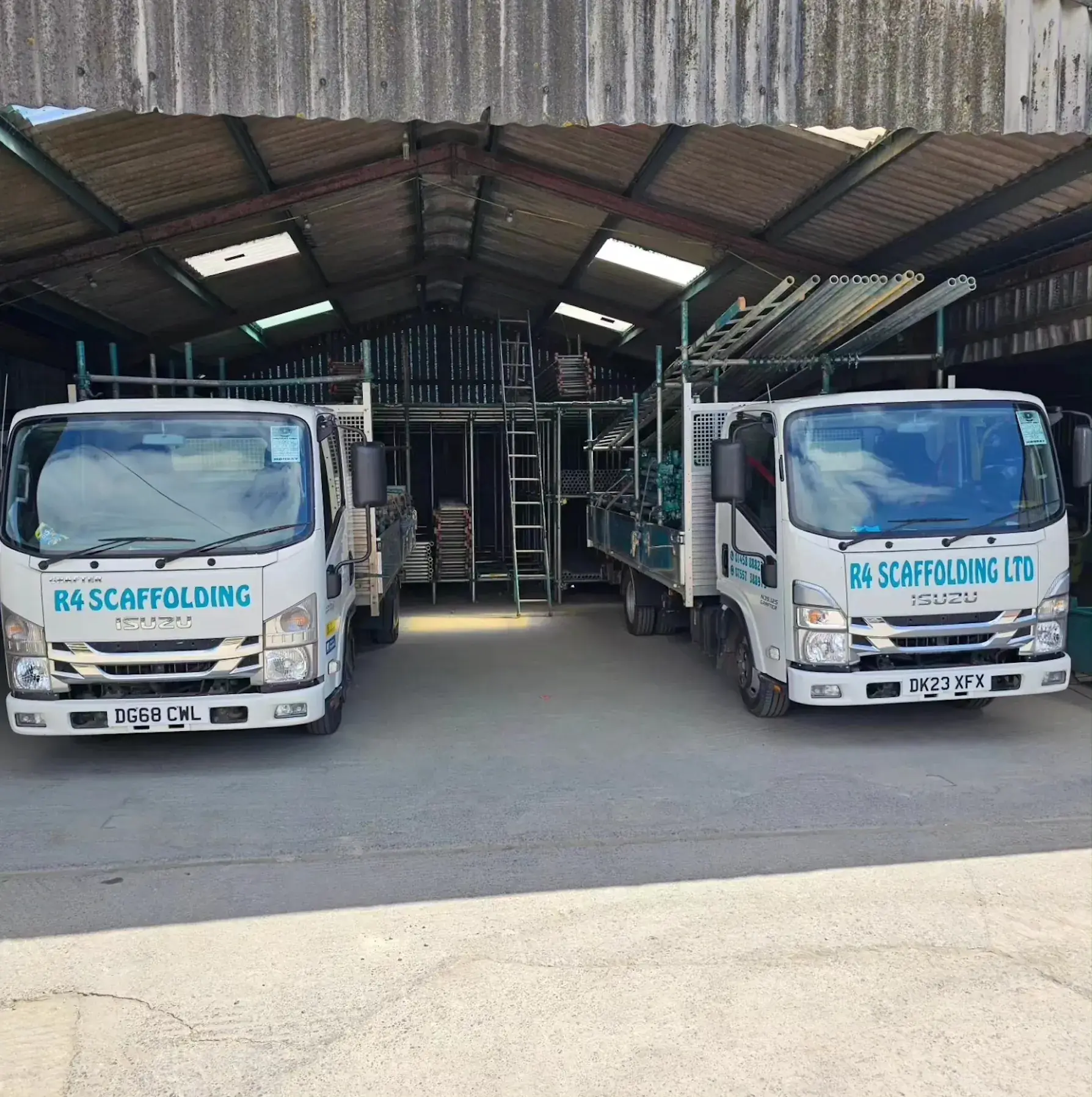 Two Isuzu flatbed trucks parked at the yard ahead of remapping