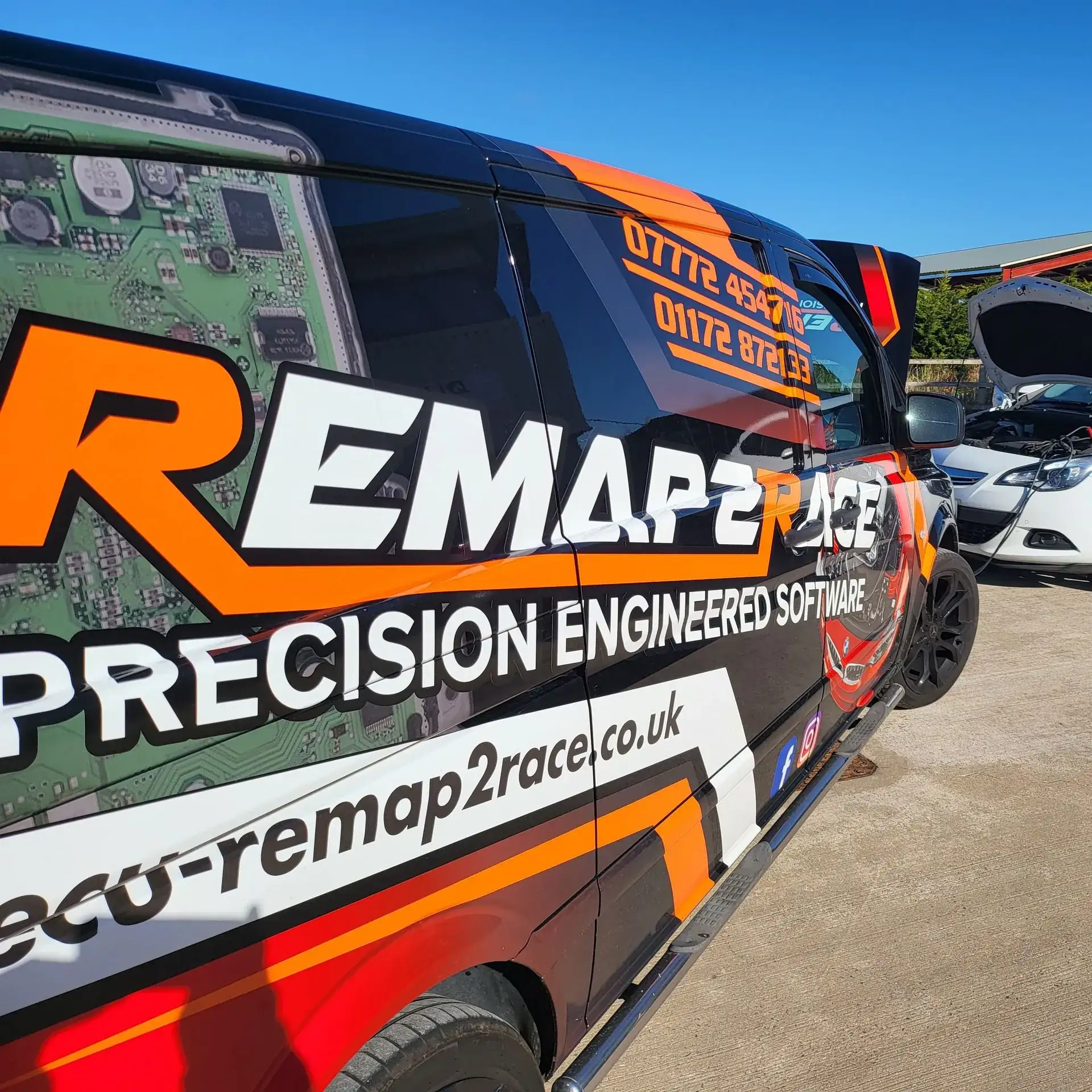 The Remap2Race van — black and orange race livery with ECU circuit-board graphics